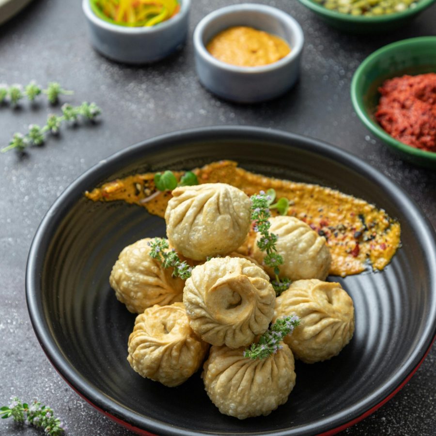 pexels-photo-5409009-5409009 A bowl of fried dumplings served with garnishes and assorted dips, showcasing traditional cuisine.